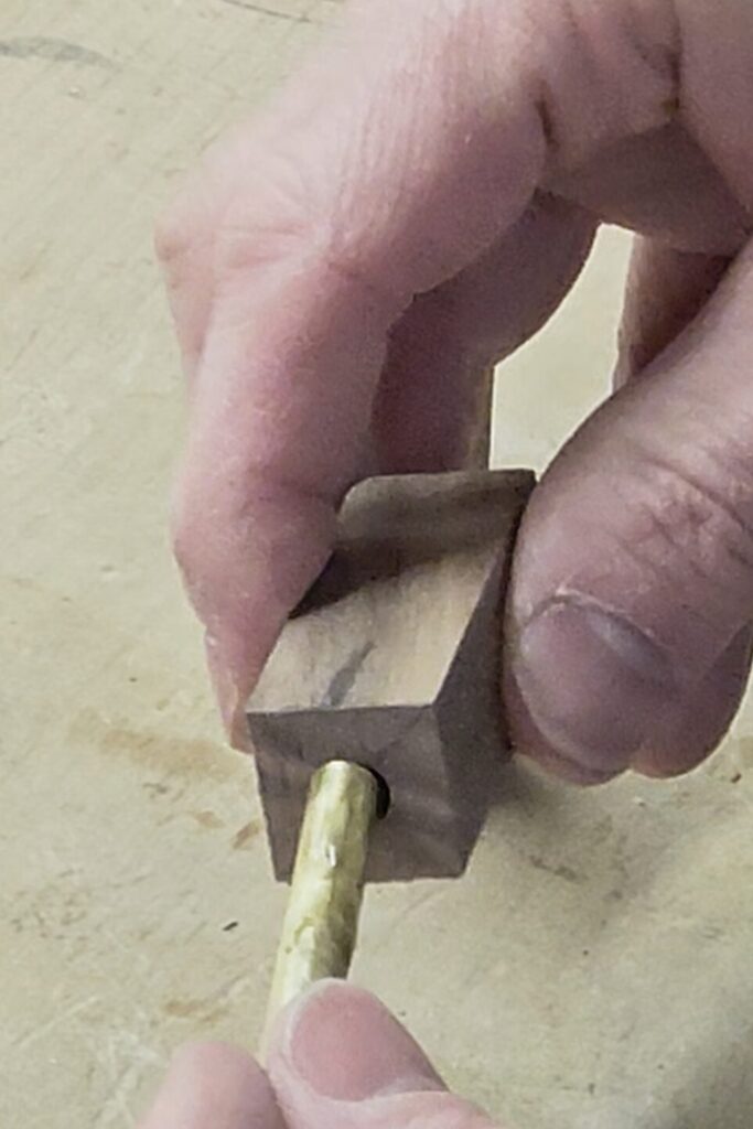 inserting a CA glue covered brass tube into the wood blank